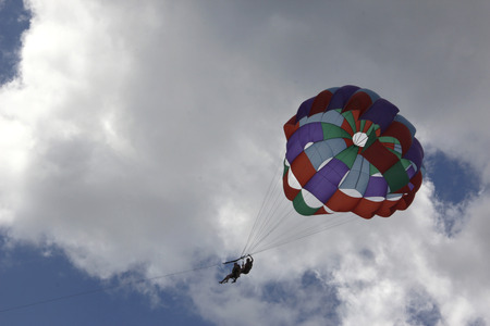 Skyrider brightly colored with two people on a background of sky with white clouds and grayのeditorial素材