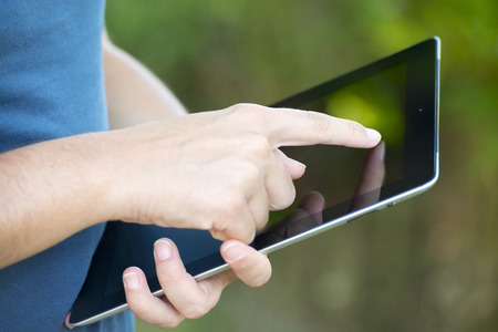 Close-up of woman hands holding digital tablet の写真素材