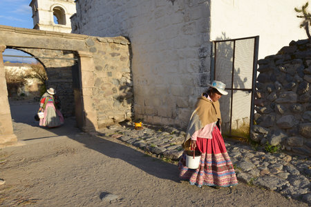 YANQUE, PERU - SEPTEMBER 3: Unidentified woman walking near the Immaculate Conception Church on September 3, 2015 in Yanque, Peru.のeditorial素材