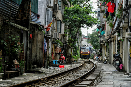 Hanoi, Vietnam - August 31: Train crossing the middle of Hanoi city with crowded houses on August 31, 2018 in Hanoi, Vietnam.のeditorial素材