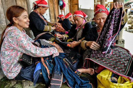 Ta Phin, Vietnam - August 24: Red Dao women sewing in the village on August 24, 2018 in Ta Phin. Red Dao people are Chinese minority in Vietnam.のeditorial素材