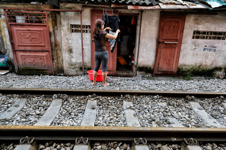 Hanoi, Vietnam - August 28: Woman hanging clothes on the train street with railroad on August 28, 2018 in Hanoi, Vietnam.のeditorial素材