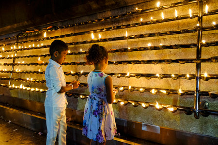 Kataragama, Sri Lanka - January 2020: Two children making offerings at the Maha Devale Hindu sanctuary on January 18, 2020 in Kataragama, Sri Lanka.のeditorial素材