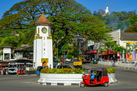 Kandy, Sri Lanka - January 2020: A tuk tuk passing in front of the clock tower on January 26, 2020 in Kandy, Sri Lanka.のeditorial素材