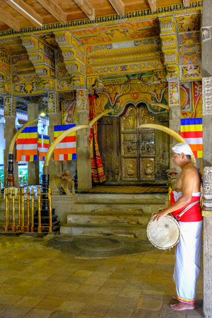 Kandy, Sri Lanka - January 2020: A man plays the drum during the offering at the Temple of the Tooth of Buddha on January 26, 2020 in Kandy, Sri Lanka.のeditorial素材
