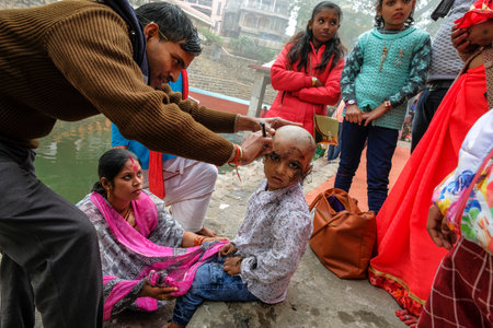 Guwahati, India - January 2021: A family celebrating Chudakarana, in which a boy receives his first haircut, at the Kamakhya Temple on January 18, 2021 in Guwahati, Assam, India.のeditorial素材