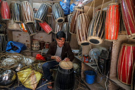 Kathmandu, Nepal - November 2021: A man making a drum in his workshop near Durbar Square on November 13, 2021 in Kathmandu, Nepal.のeditorial素材