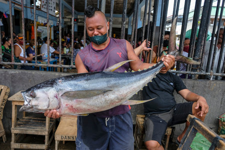 Dumaguete, Philippines - June 2022: A man selling tuna in the Dumaguete market on June 17, 2022 in Negros Oriental, Philippines.のeditorial素材