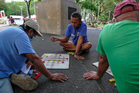 Bacolod, Philippines - June 2022: Men playing checkers at the Public Plaza in Bacolod on June 11, 2022 in Negros Occidental, Philippines.のeditorial素材