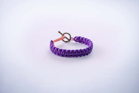Bracelet woven with purple waxed thread with a clasp to join.の写真素材
