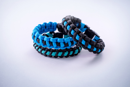 Bracelets of paracord in blue and black colors with plastic clasp to join them.