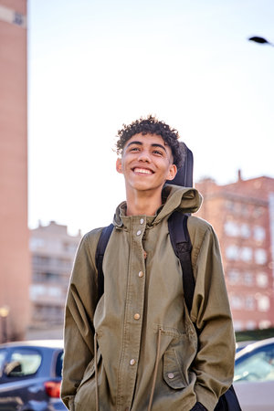 portrait of young teenager man posing outdoor with his guitar gig bag, model is Latin American Ethnic.の写真素材