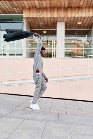 man waving his jacket over his head in celebrationの写真素材