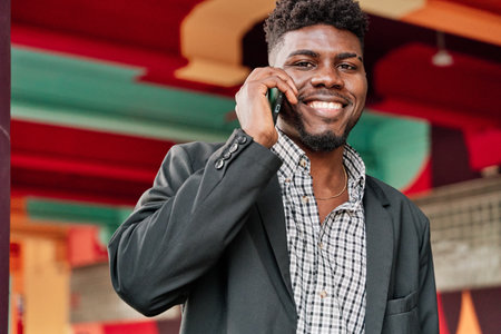 portrait of a happy African-American man talking on a smartphone with a colorful city background