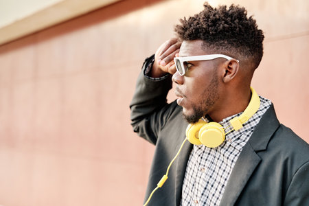 portrait of an African-American man with sunglasses touching his hair.の写真素材
