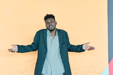 Doubtful African American man shrugging shoulders, feeling confused. Young hipster man with casual jacket looking at cameraの写真素材