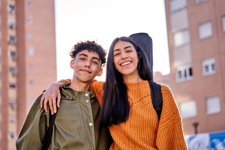 portrait of young beautiful couple smiling outdoor with guitar gig bag, models are of Latin American Ethnic and are looking at cameraの写真素材