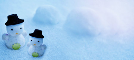 White snowman in a black hat in the snow. Blurred winter christmas background.の写真素材
