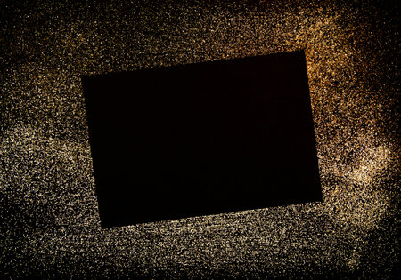 Mock up of Black paper and frame with the space for the text over the golden shimmering backgroundの写真素材