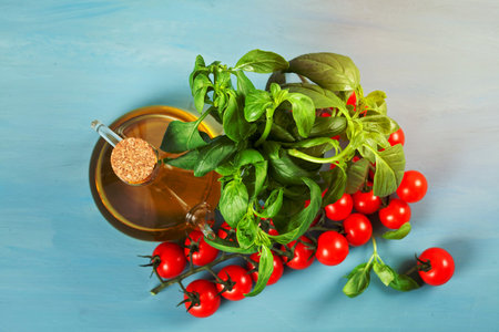 Bunch of fresh basil, tomatoes and olive oil - traditional ingredient of italian cuisineの写真素材