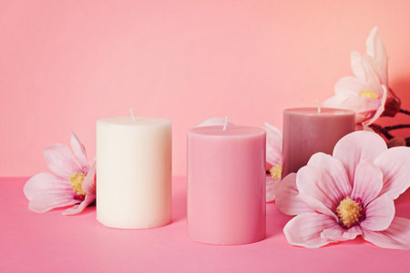 Delicate flower scented candle over the pastel pink background with copy spaceの写真素材
