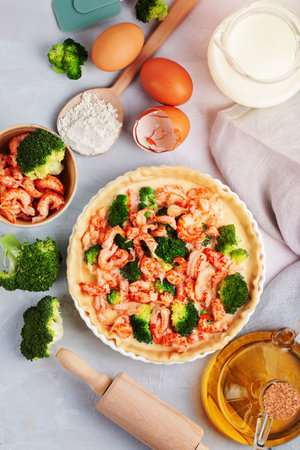 Cooking of home made french tart quiche with crayfish and broccoli filled with cream and eggs. Easy recipeの写真素材