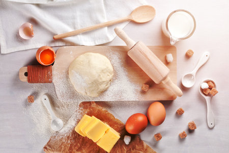 Dough preparation recipe for bread, pizza, pasta, cookies or pie ingridients, food flat lay on kitchen table background. Working with butter, milk, yeast, flour, eggs, sugar pastry or bakery cooking.の写真素材
