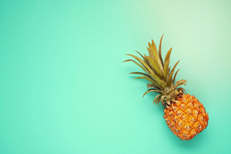 Tropical pineapple fruit top view over blue background. Summer vacation, travel, tourism concept flat lay.の写真素材