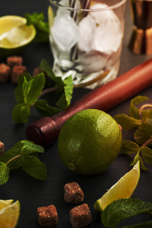 Preparation of Mojito cocktail. Bar utensils and ingredients mint, lime, ice and cane sugar. Top view with copy spaceの写真素材