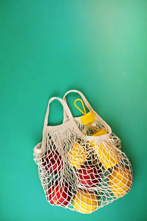Reusable shopping mesh bag with lemons, fruits and glass bottle. Zero waste, plastic free concept....