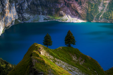 A blue mountain lake surrounded by mountainsの写真素材