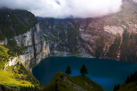 A blue mountain lake surrounded by mountainsの写真素材