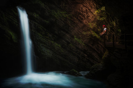 A mystical waterfall, on a scaffold sits a thoughtful person