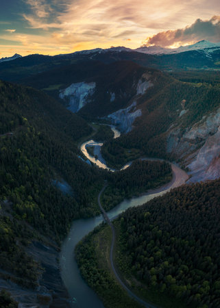 A river that runs in a S curve between the mountains,towards sunsetの写真素材