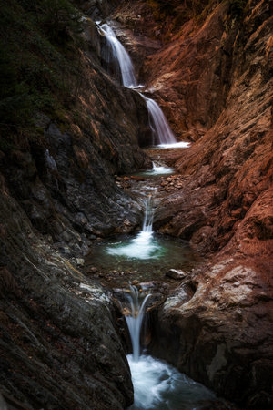 A gorge with a waterfall in the mountainsの写真素材