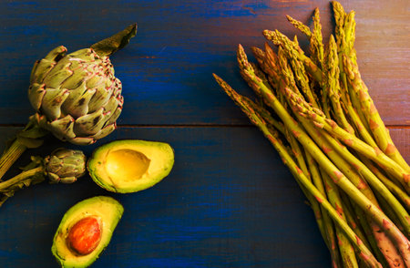 artichokes, asparagus and avocados on blue wooden rustic backgroundの写真素材