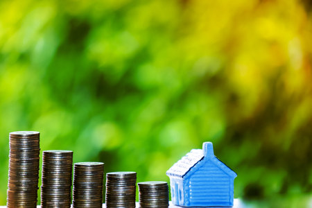 House model and coins money, Business Finance coin stack growing graph with green tree bokeh background,investment, loans and real estate conceptの写真素材
