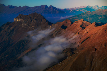 Cold bluish mountain landscape in fog at sunriseの写真素材