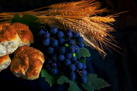 wheat grapes bread and crown of thorns on black background as a symbol of Christianityの写真素材