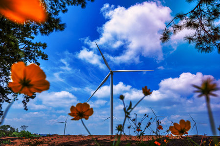 Wind turbines on mountain with blue sky and branch tree in Thailand.の写真素材