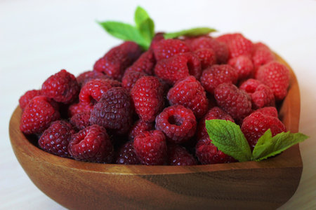 Close-up of a raspberry in a wooden container on a white backgroundの写真素材