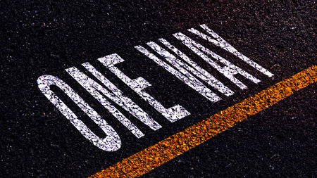 One way text written and yellow line on the road in middle of the asphalt road, One way word on...