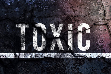 Toxic text written and white line with broken cement wall, Toxic sign word on street.の写真素材