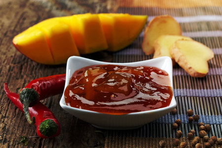 Bowl of Mango Chutney on old wooden tableの写真素材