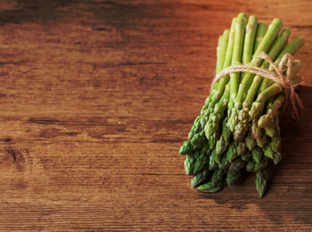 Bunch of fresh asparagus on wooden tableの写真素材