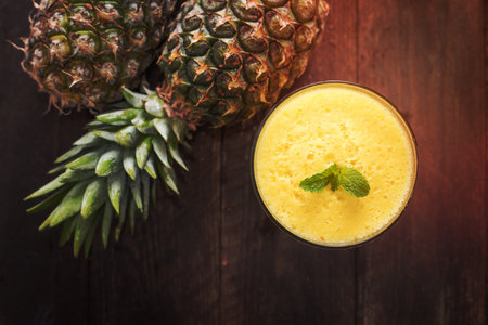 Top pineapple smoothie on wooden table.の写真素材