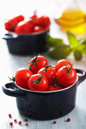 cherry tomatoes and basil in casseroleの写真素材