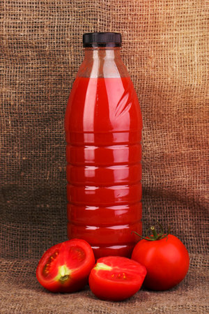 Tomato juice in bottle on sackcloth backgroundの写真素材