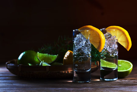 Gin with lemon and ice on a old wooden table