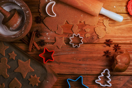 Cutting Christmas cookies on wooden tableの写真素材